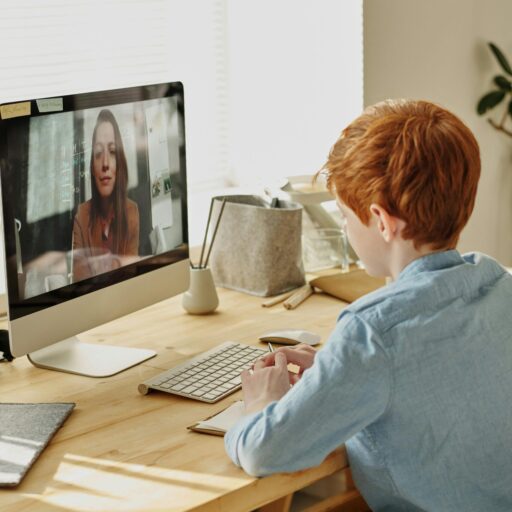 Boy in Blue Dress Shirt Sitting in Front of Silver Imac