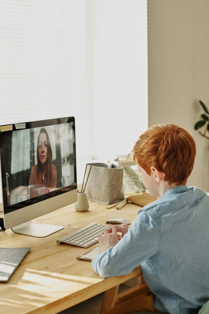 Boy in Blue Dress Shirt Sitting in Front of Silver Imac